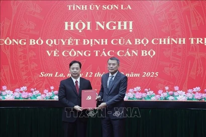 Le Minh Hung (der.), miembro del Buró Político, secretario del Comité Central del Partido y jefe de su Comisión de Organización, presenta la decisión de nombramiento a Hoang Van Nghiem. (Foto: VNA)