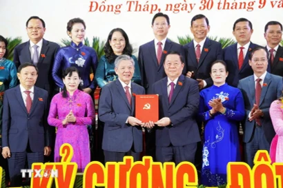 Nguyen Trong Nghia (tercero, a la derecha), miembro del Buró Político, secretario del Comité Central del Partido Comunista de Vietnam y jefe de su Comisión de Propaganda, Educación y Movilización de Masas, presenta una decisión al nuevo secretario del Comité del Partido de Dong Thap, Ngo Chi Cuong. (Foto: VNA)