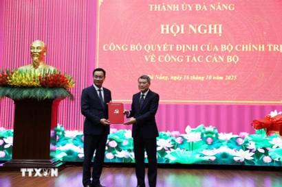 Le Minh Hung, (derecha) miembro del Buró Político, secretario del Comité Central del PCV y jefe de su Comisión de Organización, presenta la decisión del nombramiento a Le Ngoc Quang. (Foto: VNA)