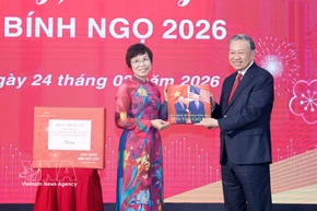 La directora general de la VNA, Vu Viet Trang, obsequia al secretario general To Lam un libro fotográfico realizado por reporteros de la agencia. Foto: VNA