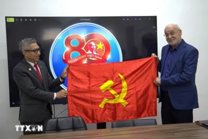 El embajador de Vietnam en Israel, Ly Duc Trung entrega una bandera del Partido Comunista de Vietnam a Issam Makhoul, presidente de Hadash (Foto: VNA)