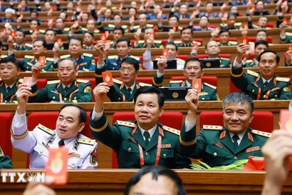 Los delegados votan para aprobar la Resolución del XIV Congreso Nacional del Partido. (Foto: VNA)