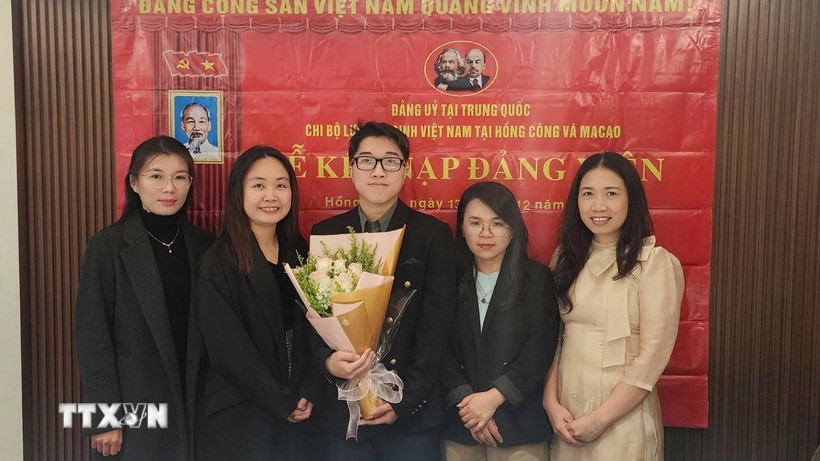 Nguyen Thi Xuan Hue (segunda desde la izquierda), estudiante de doctorado en Lingüística Inglesa Aplicada de la Universidad de Macao (China), en una ceremonia de admisión de nuevos miembros del partido. (Fuente: VNA)