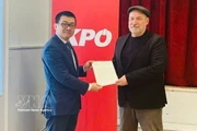 El embajador de Vietnam en Austria, Vu Le Thai Hoang, entrega la carta de agradecimiento del Comité Central del PCV al presidente del KPÖ, Günther Hopfgartner. (Foto: VNA)