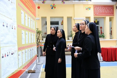 Monjes de la Congregación de las Hermanas de la Caridad de la Santa Cruz consultan la lista de candidatos en el colegio electoral No. 1, barrio de Hoan Kiem, Hanoi. Foto: VNA
