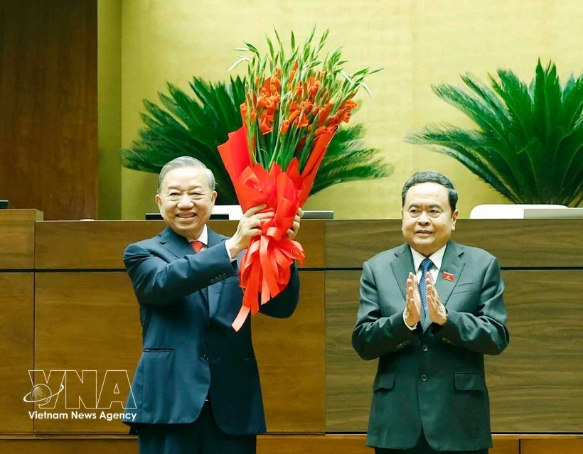 El presidente de la Asamblea Nacional, Tran Thanh Man (derecha), entrega flores para felicitar al secretario general del Partido y jefe del Estado, To Lam. (Foto: VNA)