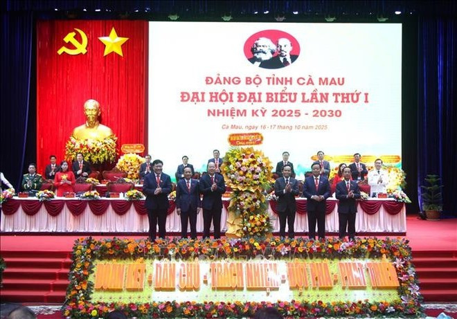Tran Luu Quang, secretario del Comité Central del Partido y secretario del Comité del Partido de Ciudad Ho Chi Minh (tercero desde la derecha, primera fila), presenta flores para felicitar a la Asamblea. (Foto: VNA) ca-mau-2.jpg