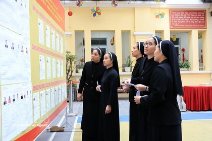 Monjes de la Congregación de las Hermanas de la Caridad de la Santa Cruz consultan la lista de candidatos en el colegio electoral No. 1, barrio de Hoan Kiem, Hanoi. Foto: VNA