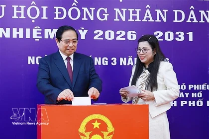 El primer ministro de Vietnam, Pham Minh Chinh, y su cónyuge emiten su voto en el colegio electoral número 21, ubicado en el barrio de Tay Ho, en Hanoi. (Foto: VNA)