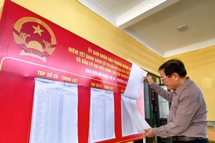 Los electores siguen la información de los candidatos antes de votar. (Foto: VNA)