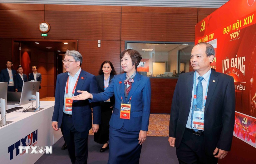 El miembro del Comité Central del Partido y ministro de Justicia, Nguyen Hai Ninh (izq.), visita el área de trabajo de la Agencia Vietnamita de Noticias en el centro de prensa del XIV Congreso Nacional del Partido. (Fuente: VNA)