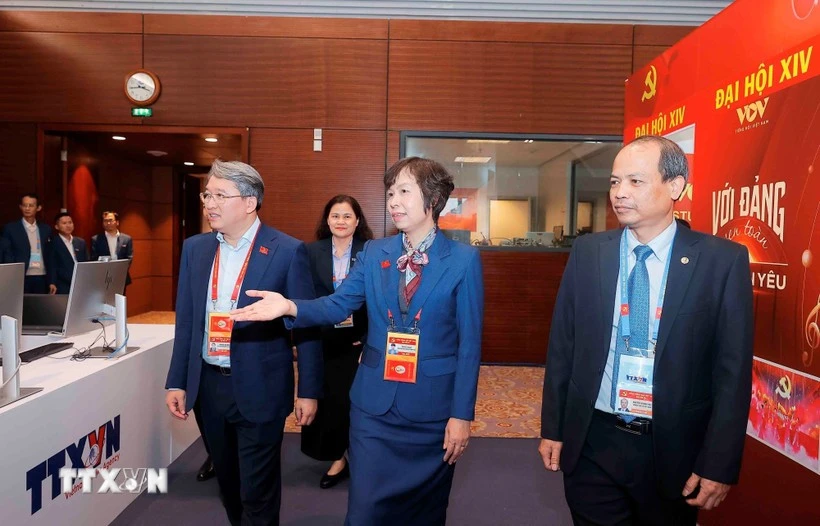 El miembro del Comité Central del Partido y ministro de Justicia, Nguyen Hai Ninh (izq.), visita el área de trabajo de la Agencia Vietnamita de Noticias en el centro de prensa del XIV Congreso Nacional del Partido. (Fuente: VNA)