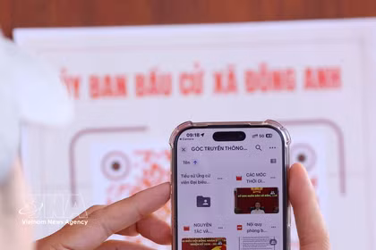 Los votantes escanean códigos QR con sus teléfonos inteligentes para consultar rápidamente información relacionada con sus derechos de voto. Foto: Van Diep – VNA