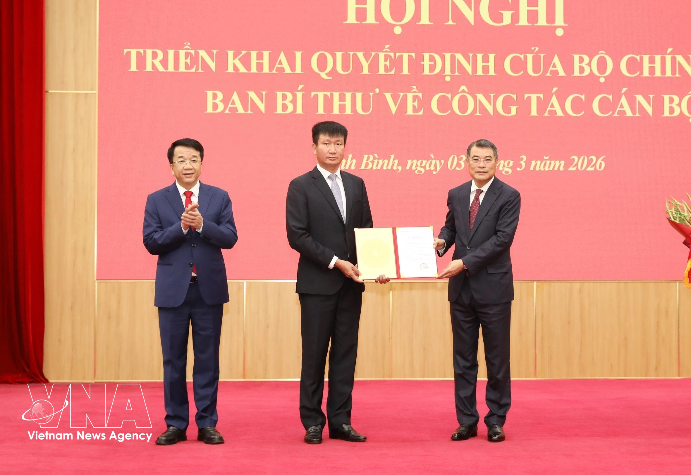 Le Minh Hung, miembro del Buró Político, secretario del Comité Central del Partido y jefe de su Comisión de Organización, entrega la decisión a Tran Huy Tuan. (Foto: VNA)
