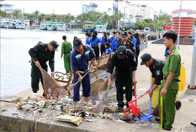 Miembros de la Unión de Jóvenes de la Fuerza de Seguridad Pública y de la Unión de Jóvenes de la Zona Económica Especial de Phu Quoc limpian y recogen residuos. (Fuente: VNA)
