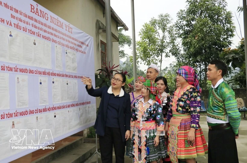 La jefa del Equipo de Encuestas No. 5 en la comuna de Quy Mong, provincia de Lao Cai, presenta las listas de candidatos a los residentes locales. (Foto: VNA)