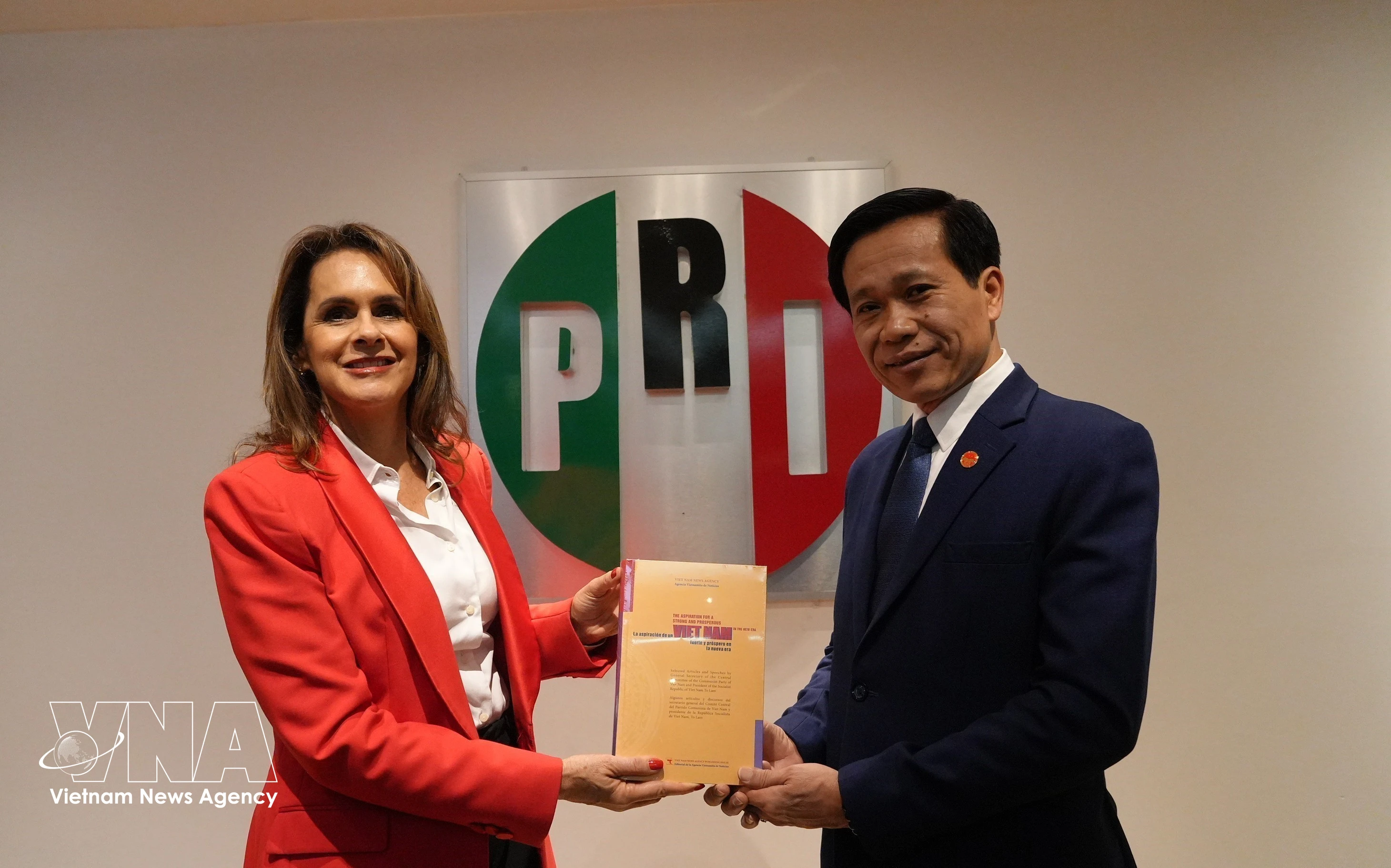 El subdirector de la Academia Nacional de Política Ho Chi Minh, Hoang Phuc Lam, entrega el libro "La aspiración de un Vietnam fuerte y próspero en la nueva era" a Sofia Carvajal, secretaria de Asuntos Internacionales del Partido Revolucionario Institucional (PRI). Foto: VNA