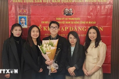 Nguyen Thi Xuan Hue (segunda desde la izquierda), estudiante de doctorado en Lingüística Inglesa Aplicada de la Universidad de Macao (China), en una ceremonia de admisión de nuevos miembros del partido. (Fuente: VNA)