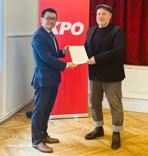 El embajador de Vietnam en Austria, Vu Le Thai Hoang, entrega la carta de agradecimiento del Comité Central del PCV al presidente del KPÖ, Günther Hopfgartner. (Foto: VNA)