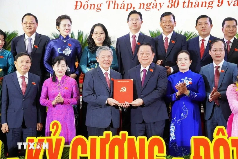 Nguyen Trong Nghia (tercero, a la derecha), miembro del Buró Político, secretario del Comité Central del Partido Comunista de Vietnam y jefe de su Comisión de Propaganda, Educación y Movilización de Masas, presenta una decisión al nuevo secretario del Comité del Partido de Dong Thap, Ngo Chi Cuong. (Foto: VNA)
