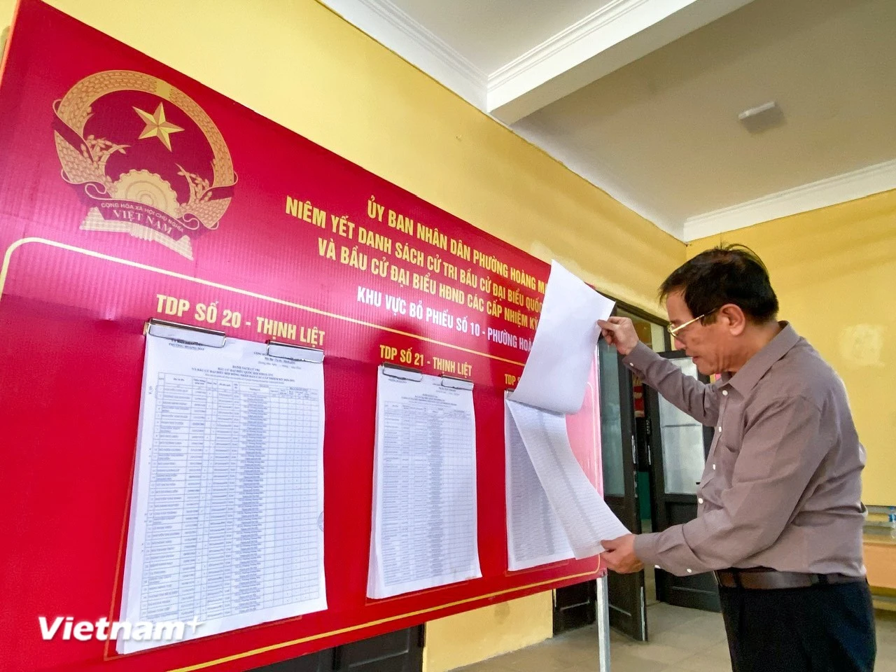 Los electores siguen la información de los candidatos antes de votar. (Foto: VNA)
