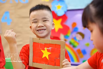 Niños vietnamitas entusiastas con la creación de la bandera nacional 