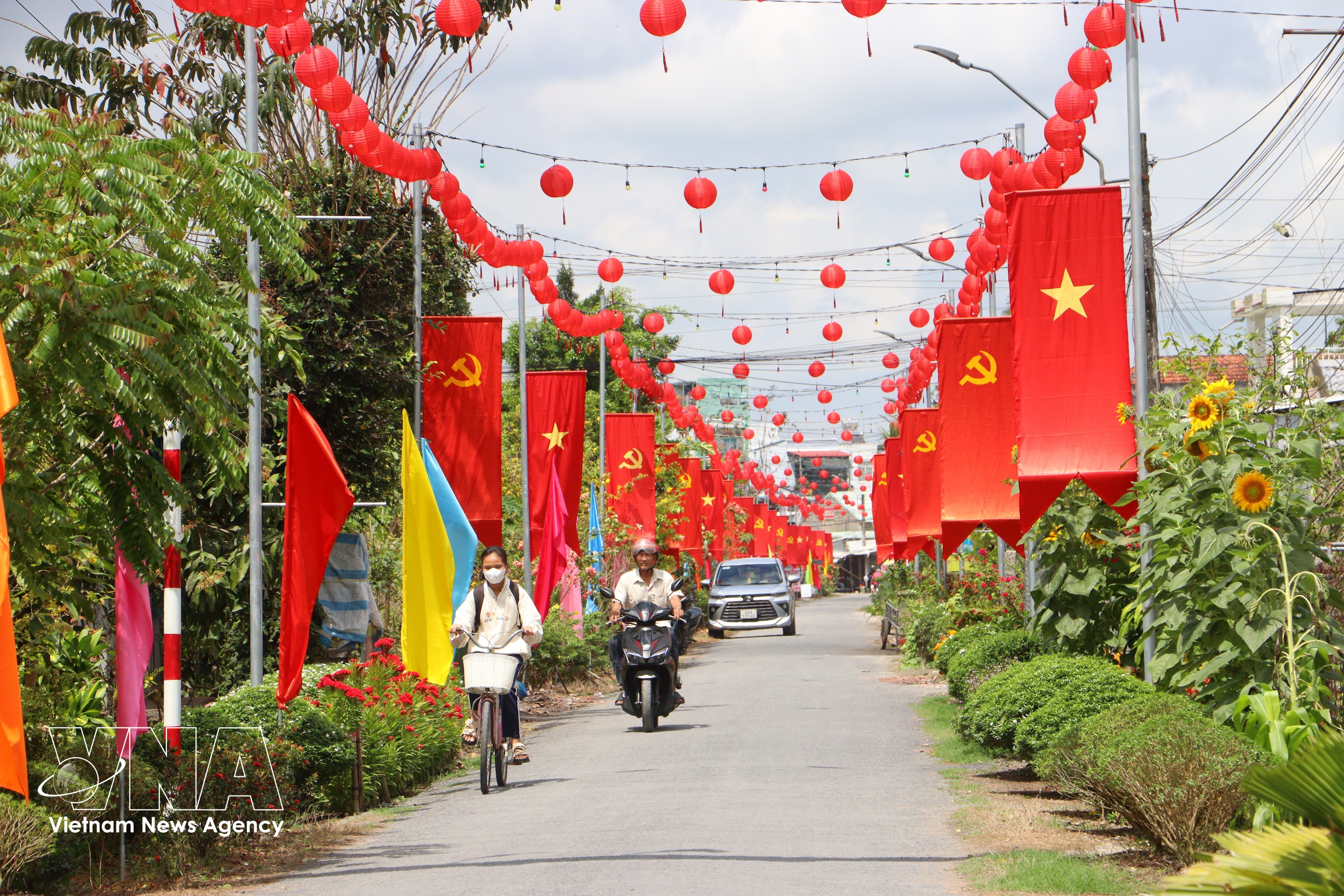 Una carretera rural en la comuna de Tra Con, provincia de Vinh Long, engalanada con banderas y flores, refleja el ambiente festivo y de expectación ante la próxima jornada electoral. (Foto: VNA)
