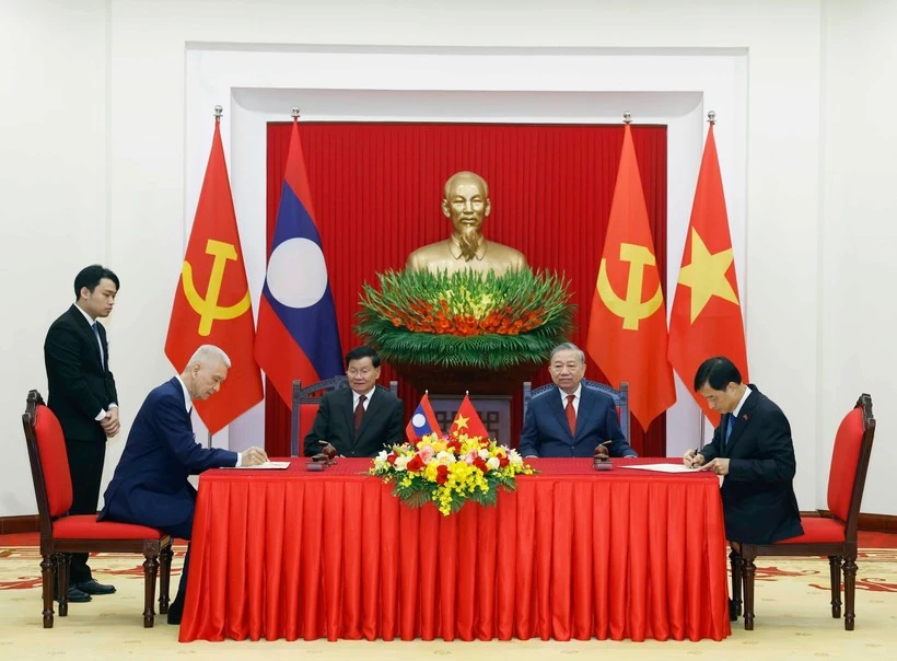 El secretario general del PCV, To Lam, y el secretario general del PPRL y presidente de Laos, Thongloun Sisoulith, presencian la firma de documentos de cooperación entre los dos países (Foto: VNA)