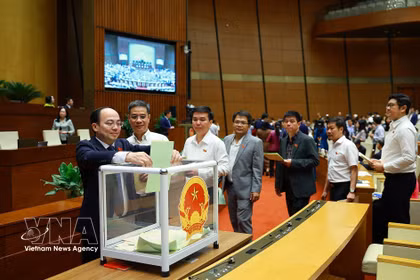 Diputados de la Asamblea Nacional emiten su voto para aprobar el nombramiento de jueces del Tribunal Popular Supremo, viceprimeros ministros, ministros y otros miembros del Gobierno. (Foto: VNA)