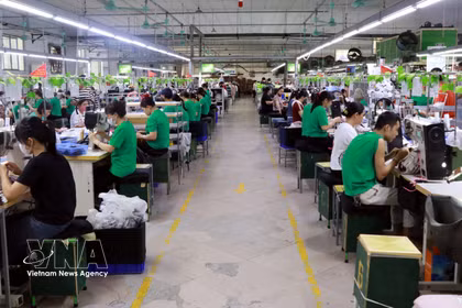 Trabajadores laboran en un taller de confección de prendas textiles destinadas a la exportación. (Foto: VNA)