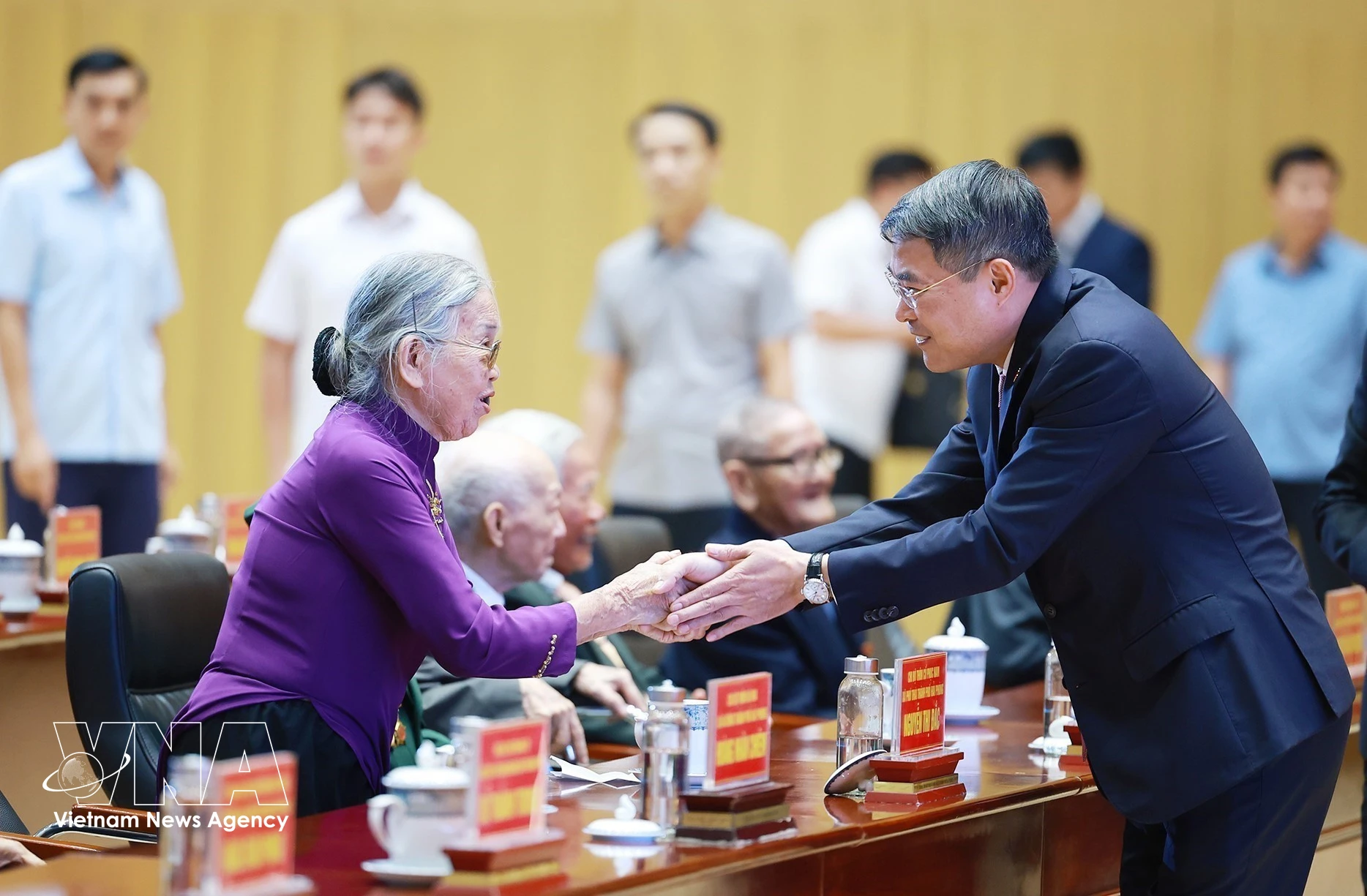 El primer ministro Le Minh Hung saluda a los militantes mayores. (Foto: VNA)