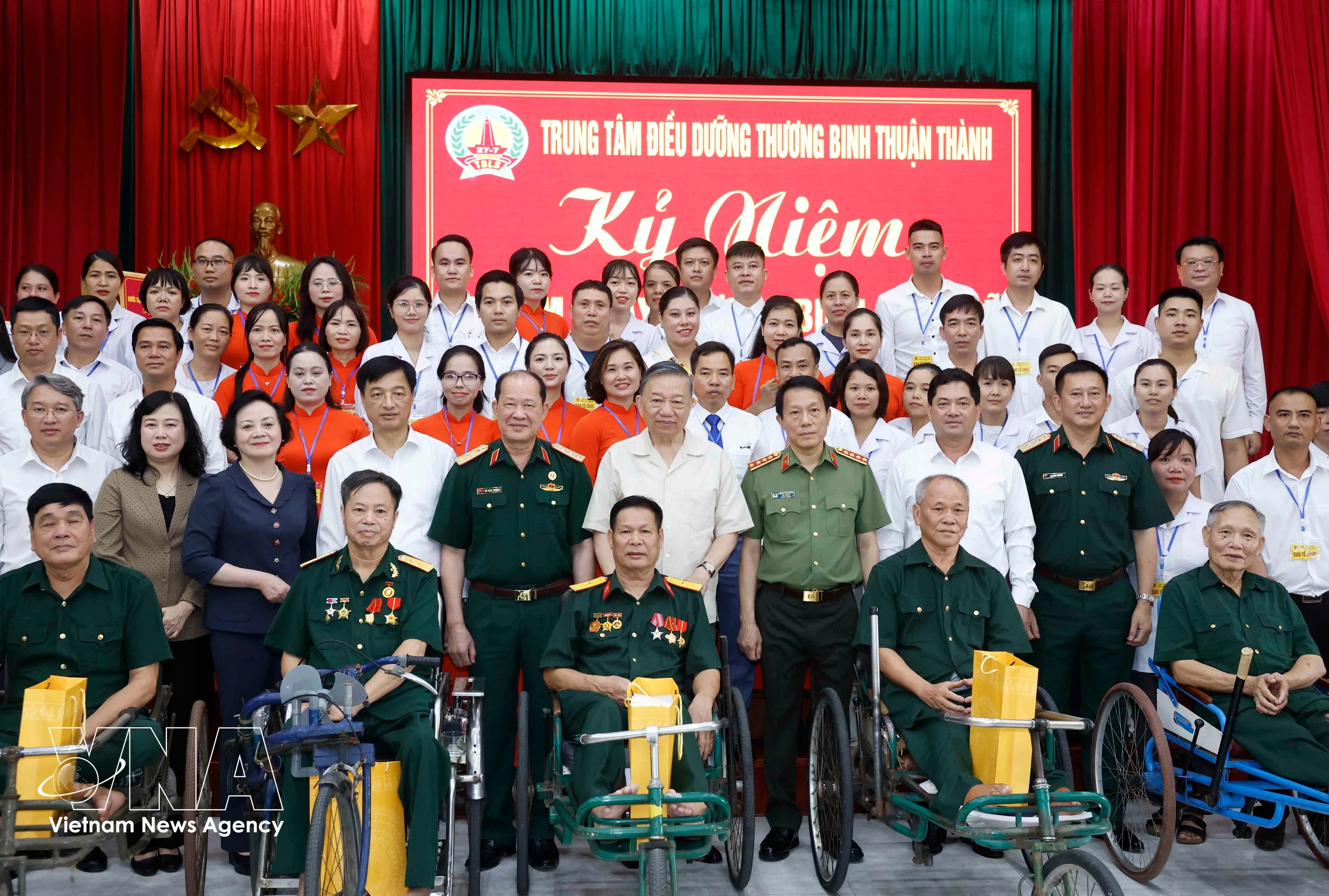 El secretario general del partido y presidente del Estado, To Lam (centro, de pie, primera fila), posa para una foto grupal con el personal, los inválidos y los soldados enfermos en el Centro de Atención para Inválidos de Thuan Thanh. (Foto: VNA)